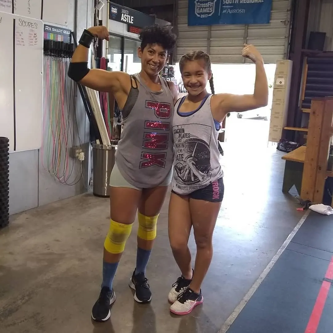 Athlete and family member flexing after a workout