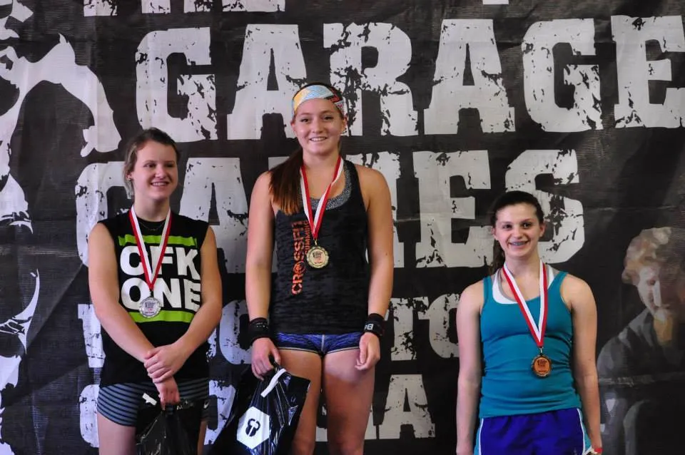 Teen athletes on the podium under the GarageGames banner