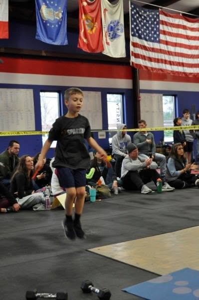 Junior athlete mid double-under at a Garage Games competition