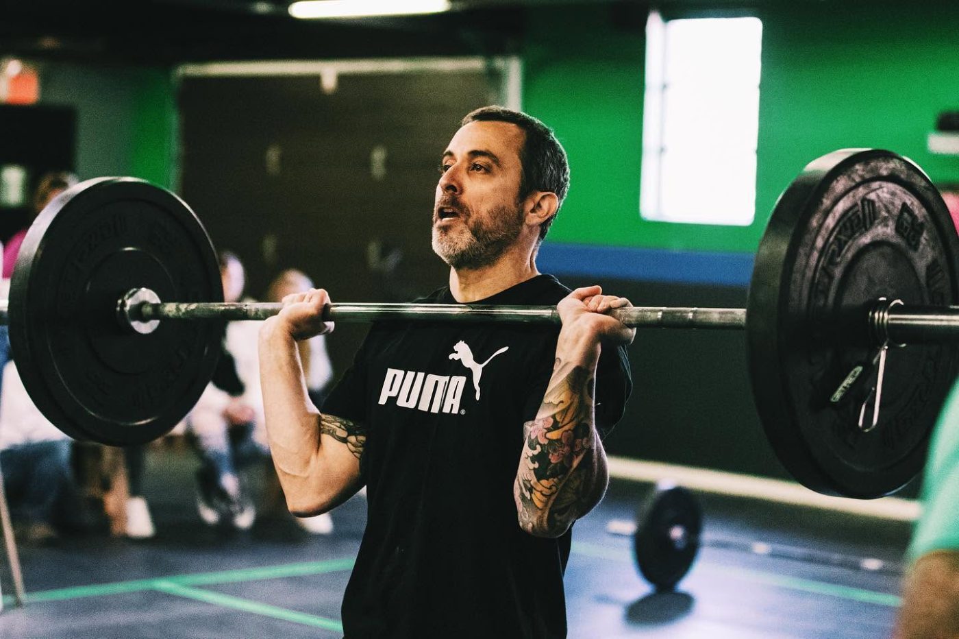 A masters athlete driving out of a heavy clean on the competition floor