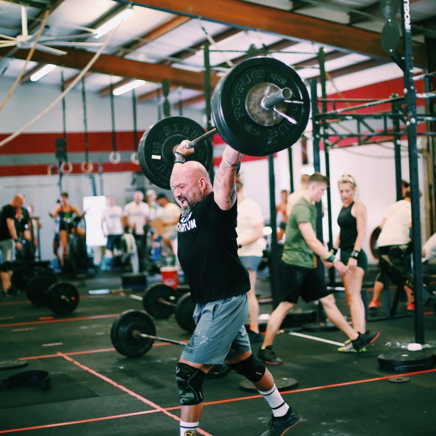 A masters athlete locking out a snatch on the competition floor